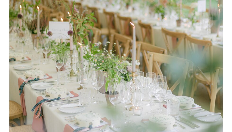 Pastel-toned wedding table adorned with garden flowers, gold candlesticks, and ivory tableware.