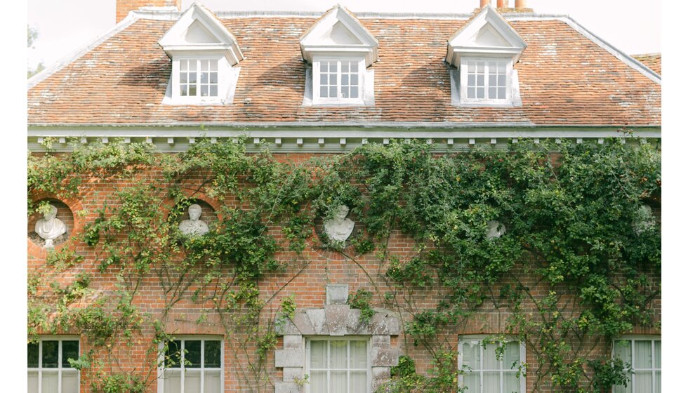 Classic English Georgian house wedding venue adorned with wall foliage in Hampshire.