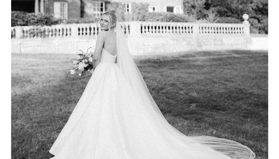 Bride in sleeveless Sassi Holford dress and veil at Hampshire outside the country house venue in Hamsphire