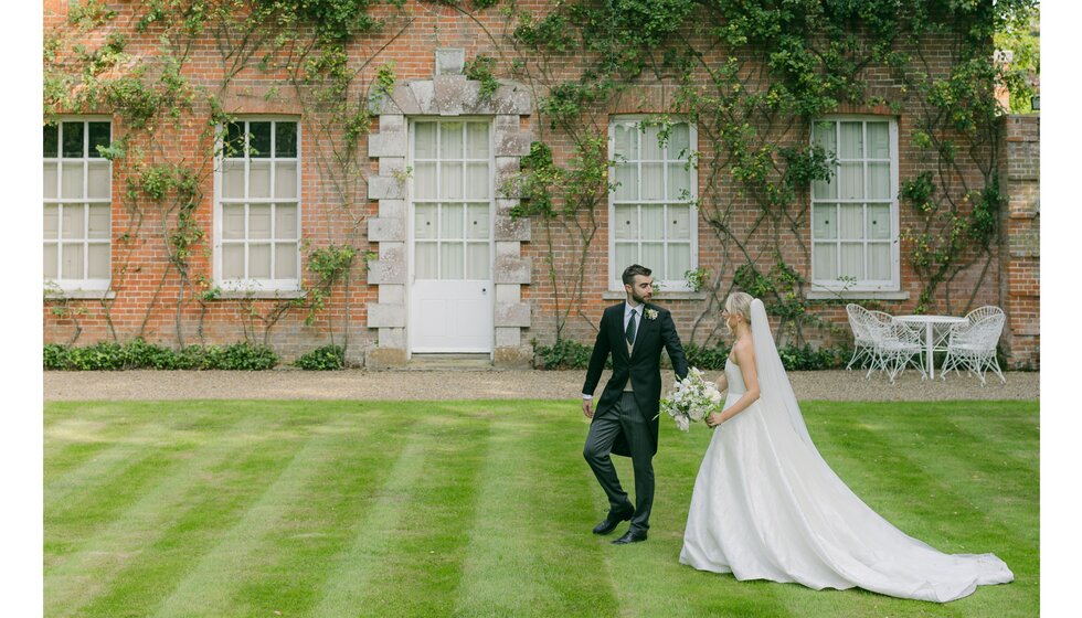 Bride and groom outside picturesque Georgian house with country garden in Hampshire.