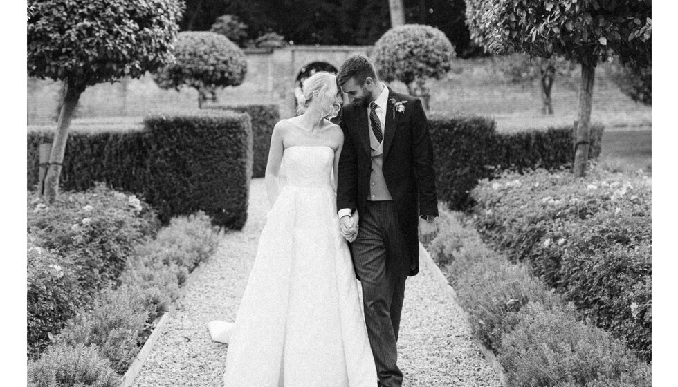Bride and groom share a tender moment in the garden of their Hampshire country house wedding venue.