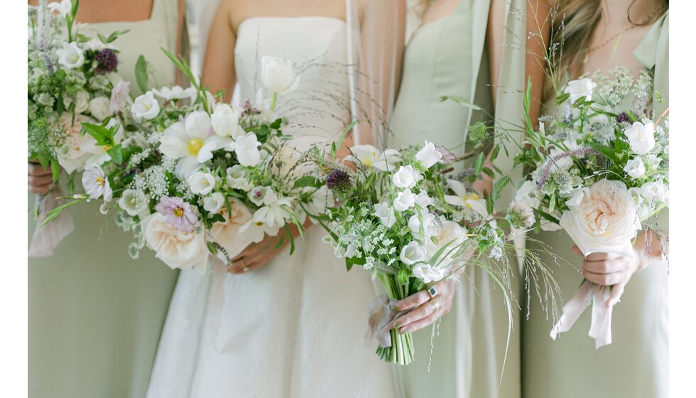 A close-up of bride and bridesmaids in mint green dresses with country garden-inspired bouquets at Hampshire wedding.