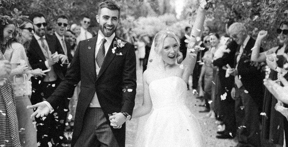 Bride and groom celebrate their English country garden wedding in Hampshire with confetti